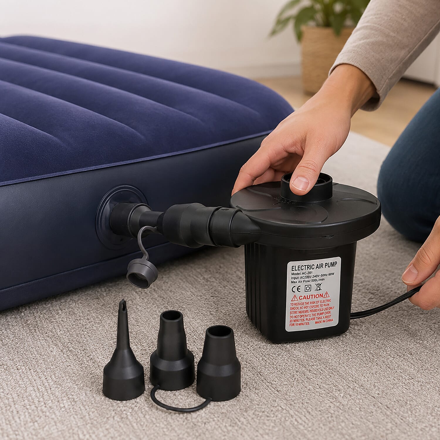 Person operating electric air pump connected to blue inflatable pool lounger with caution label visible